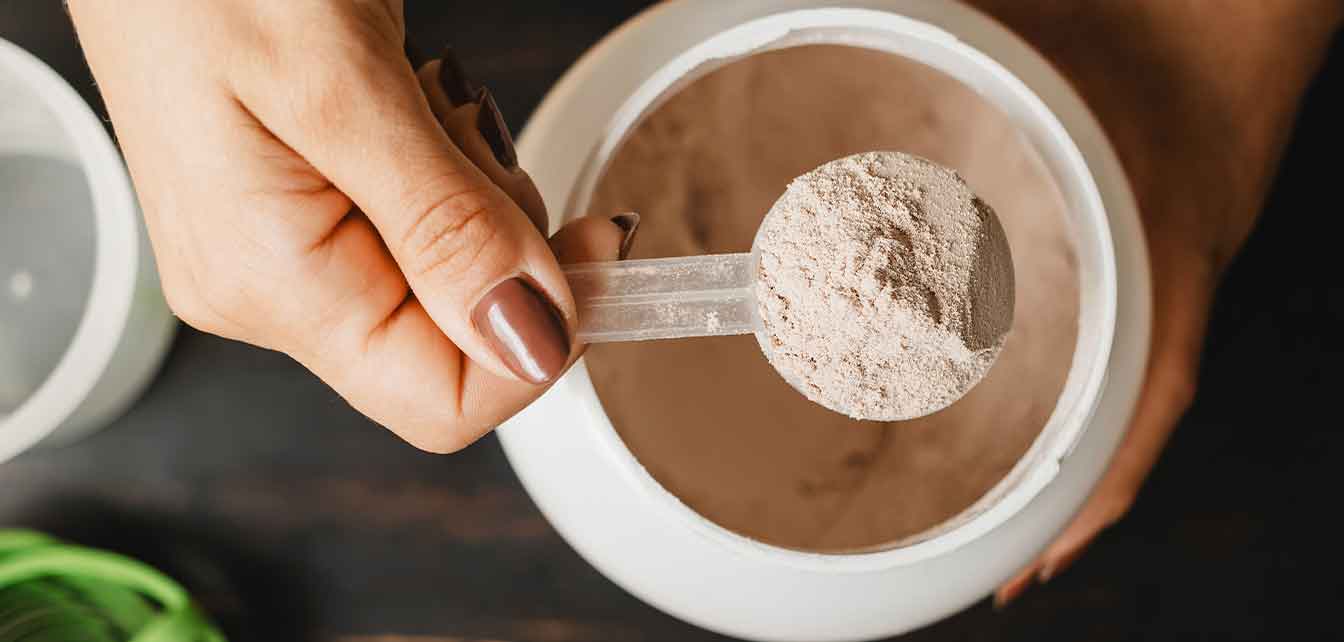 Scooping protein powder for a shake